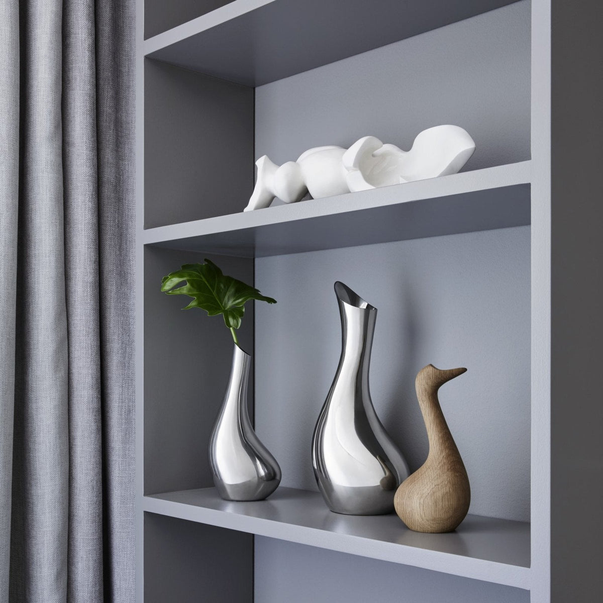 VAGNBYS Swan Carafe on a shelf beside the Swan Solitaire Vase and a wooden bird